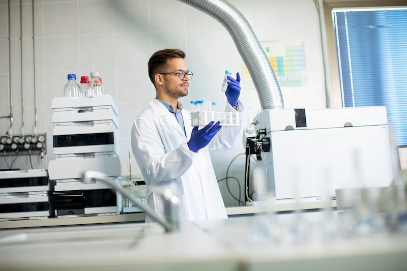 Researcher working with chemical samples in laboratory with HPLC system and chromatography equipment using Type 1 ultrapure water as part of the research